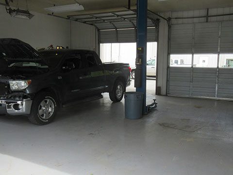 Black truck inside auto garage | Car Repair Services by Candy Apple Custom Collision II in Cartersville, GA
